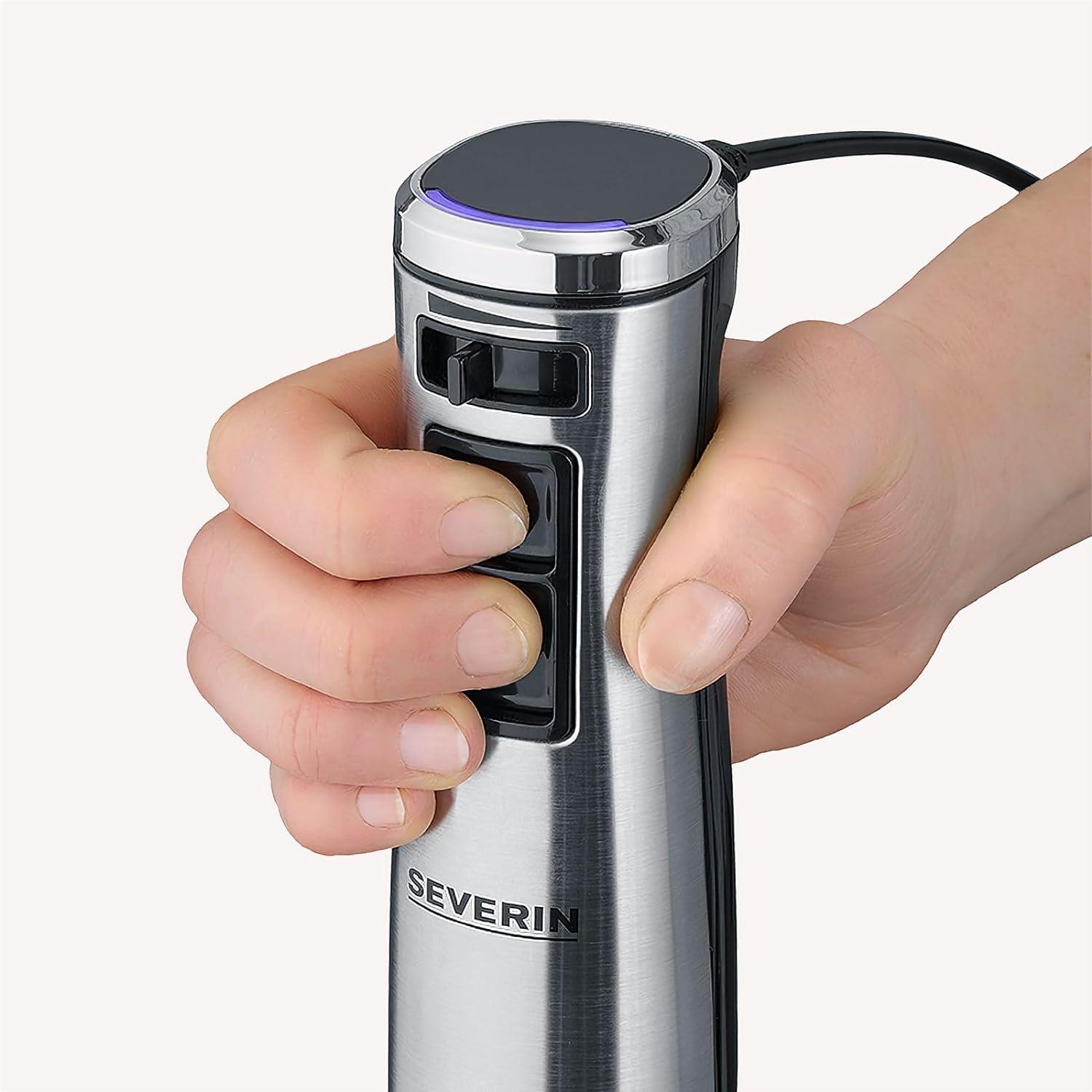 Hand hält silbernen Stabmixer mit schwarzen Knöpfen und blauem Licht.