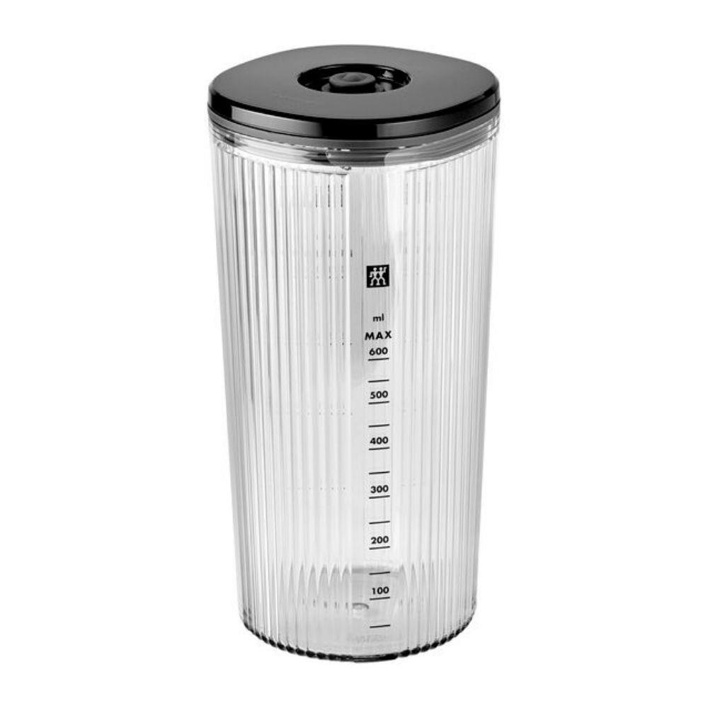 Przezroczysty kubek z miarką, czarną pokrywką i oznaczeniami od 100 do 600 ml.