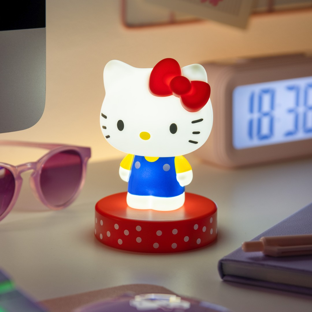 Świecąca figurka Hello Kitty na czerwonej podstawie w białe kropki.