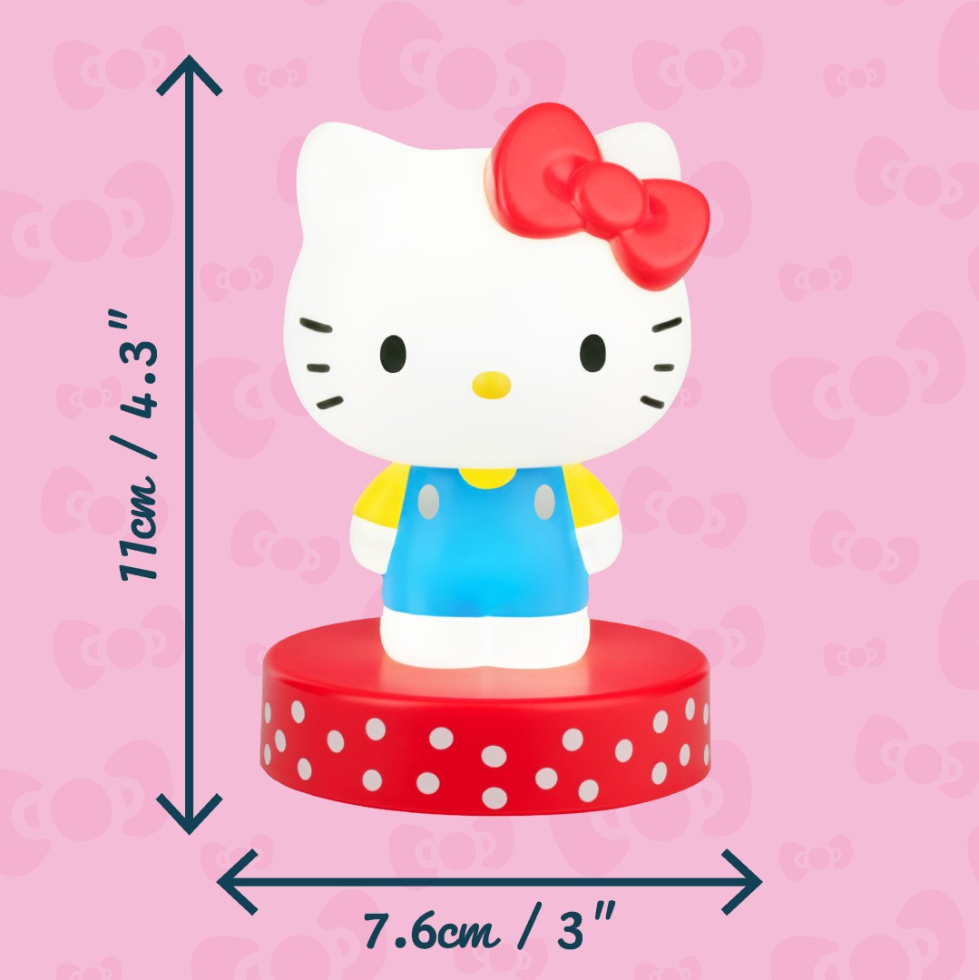 Figurka Hello Kitty na czerwonej podstawie z białymi kropkami. Wymiary 11x7.6cm. Różowe tło.