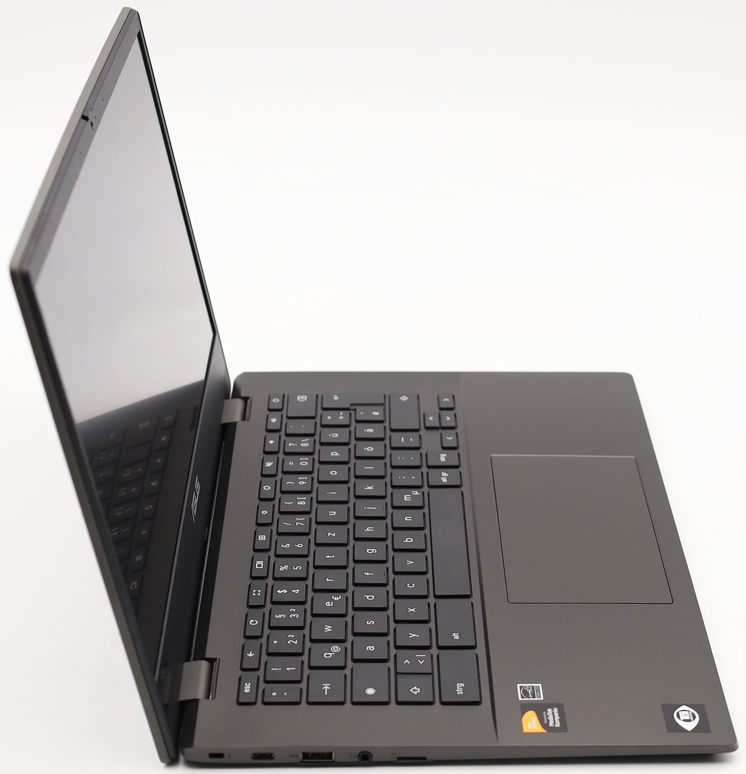 Ein dunkelgrauer Laptop ist geöffnet, nach rechts abgewinkelt, auf weißem Hintergrund.