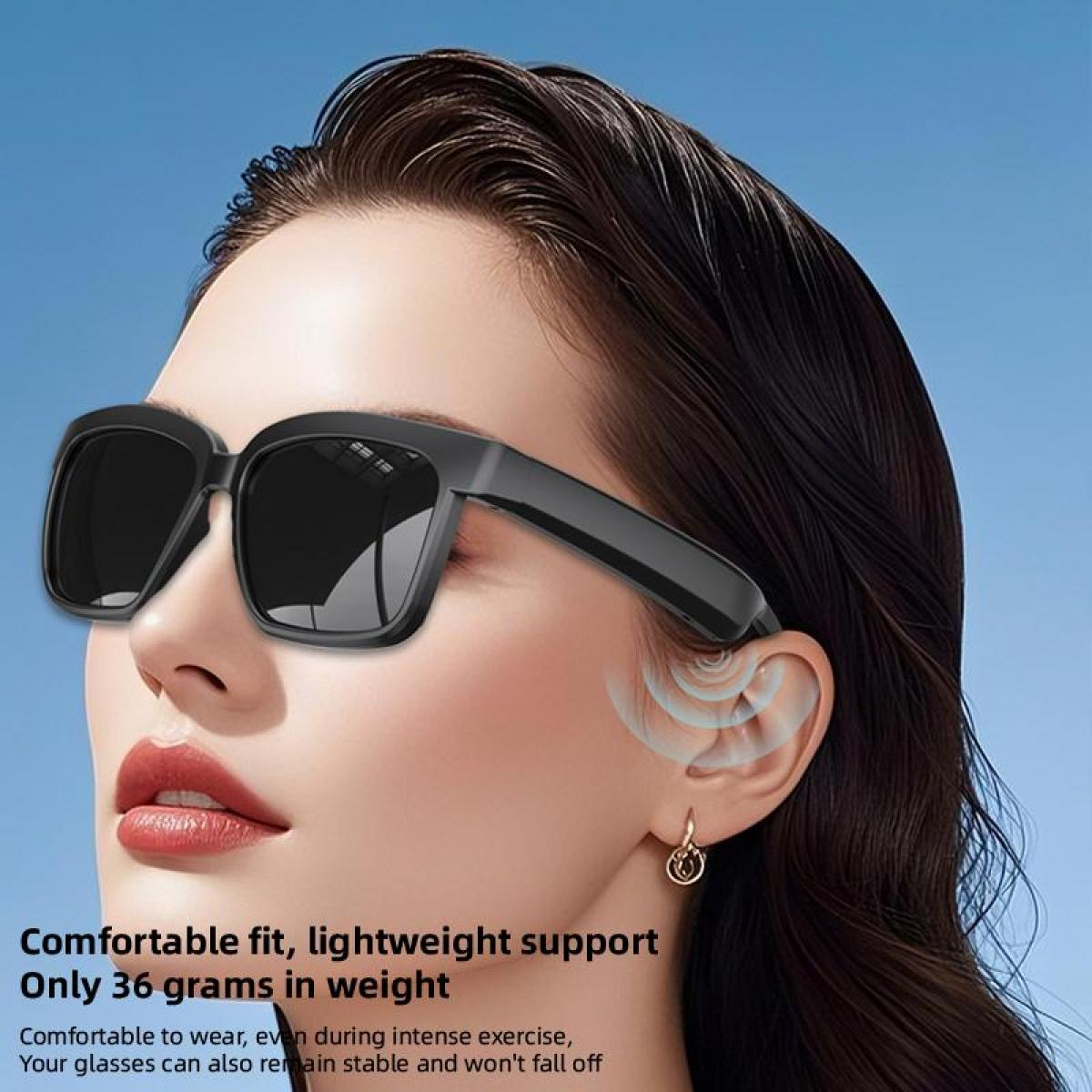 Eine Nahaufnahme einer Frau, die eine schwarze Sonnenbrille mit breiten Bügeln trägt.