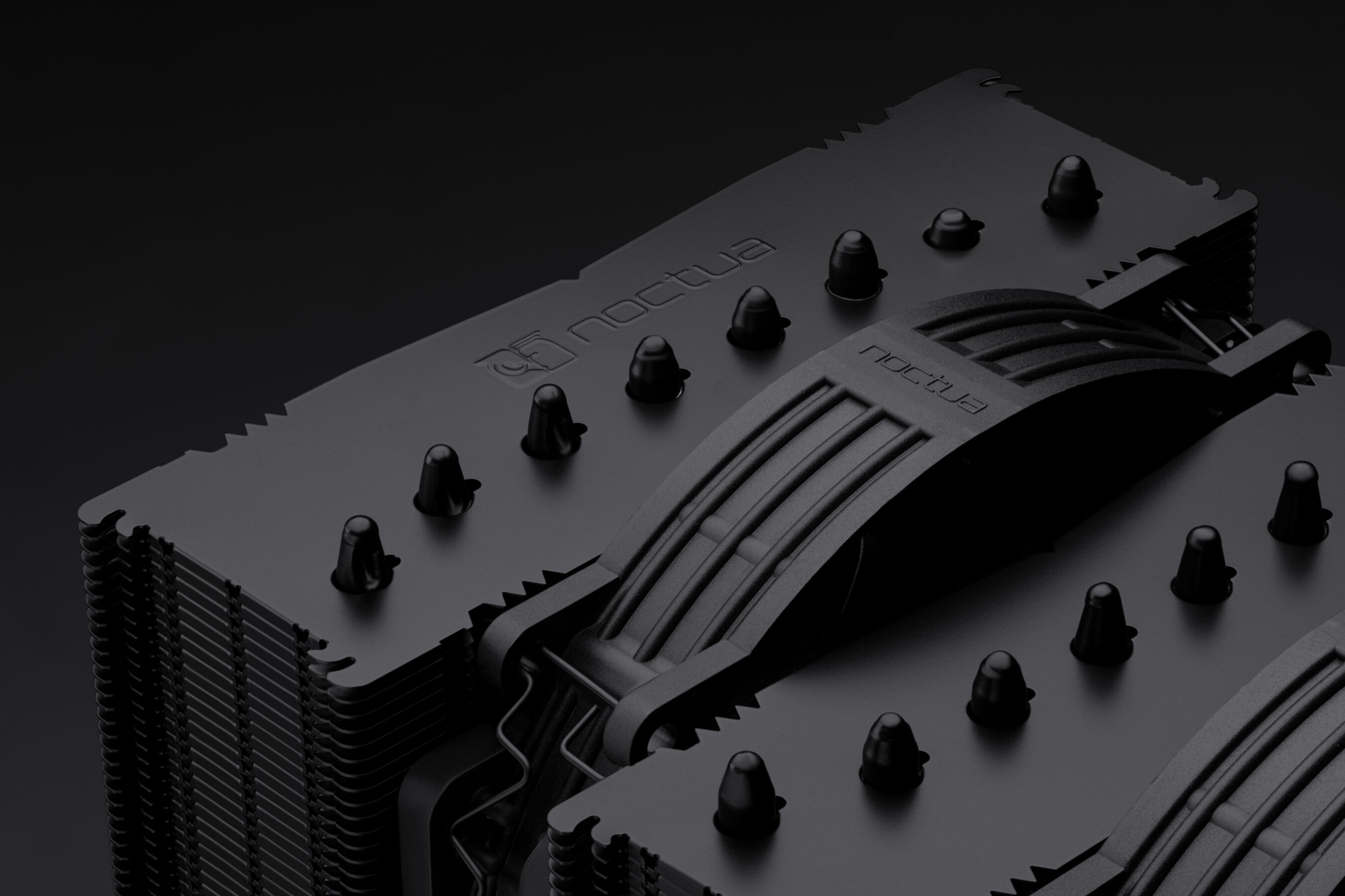 Czarny cooler Noctua CPU z metalowymi żeberkami i mechanizmem clip.