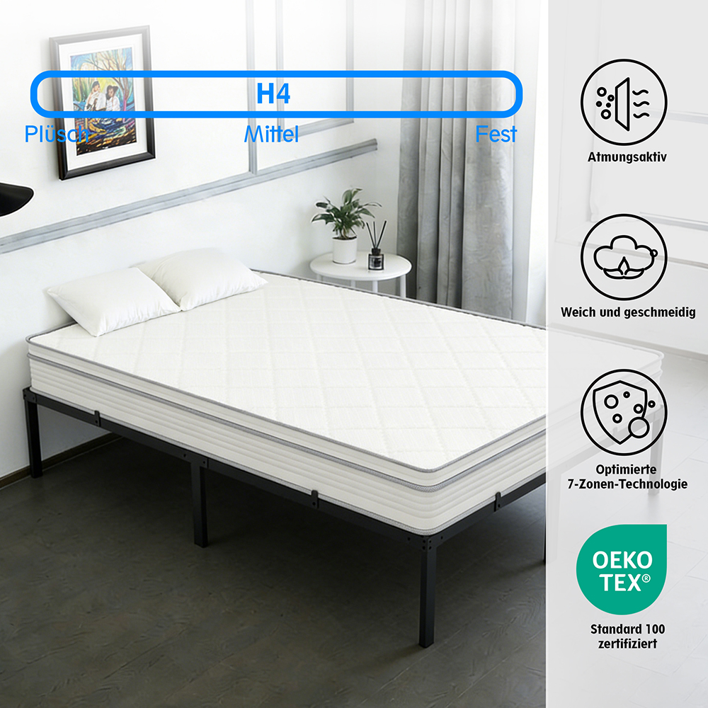 Ein weißes Bett mit zwei Kissen auf einem schwarzen Metallrahmen.