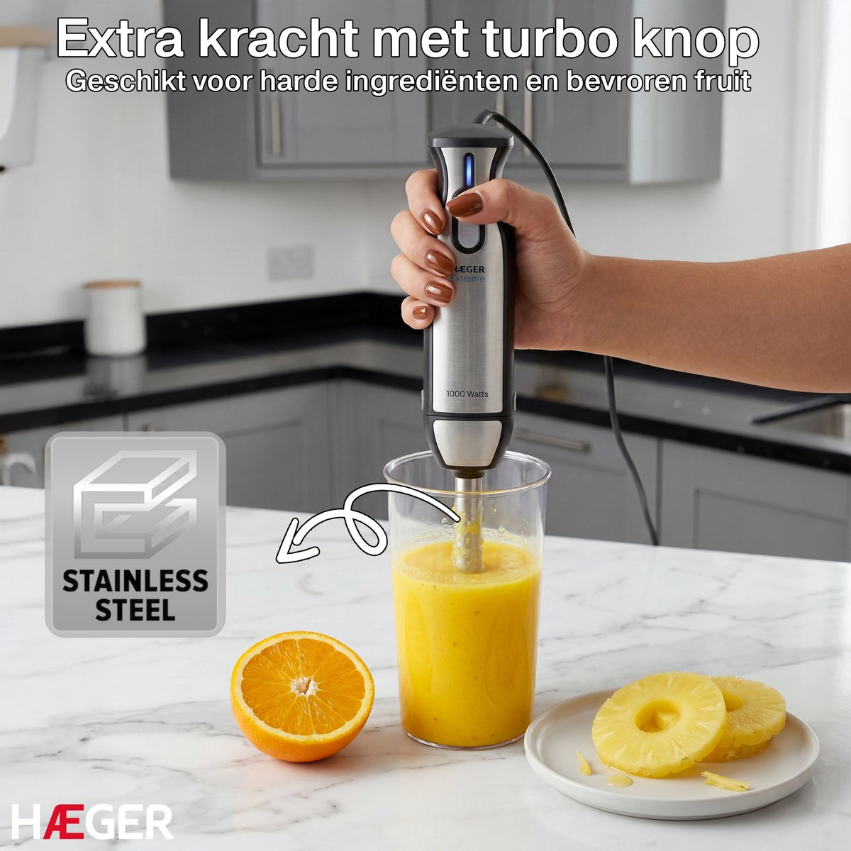 RVS staafmixer mixt sinaasappel-ananas sap in een glas.