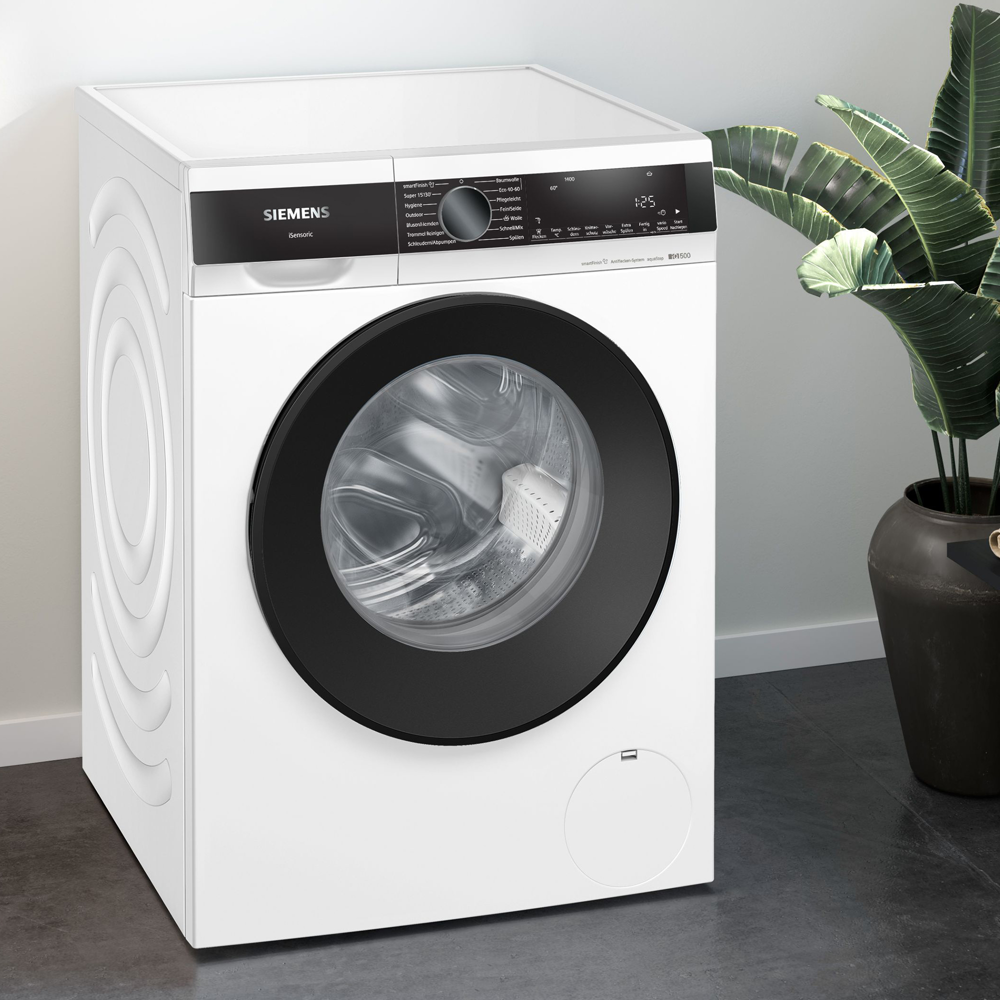 Eine weiße Siemens Waschmaschine mit schwarzer Tür steht auf einem dunklen Boden.