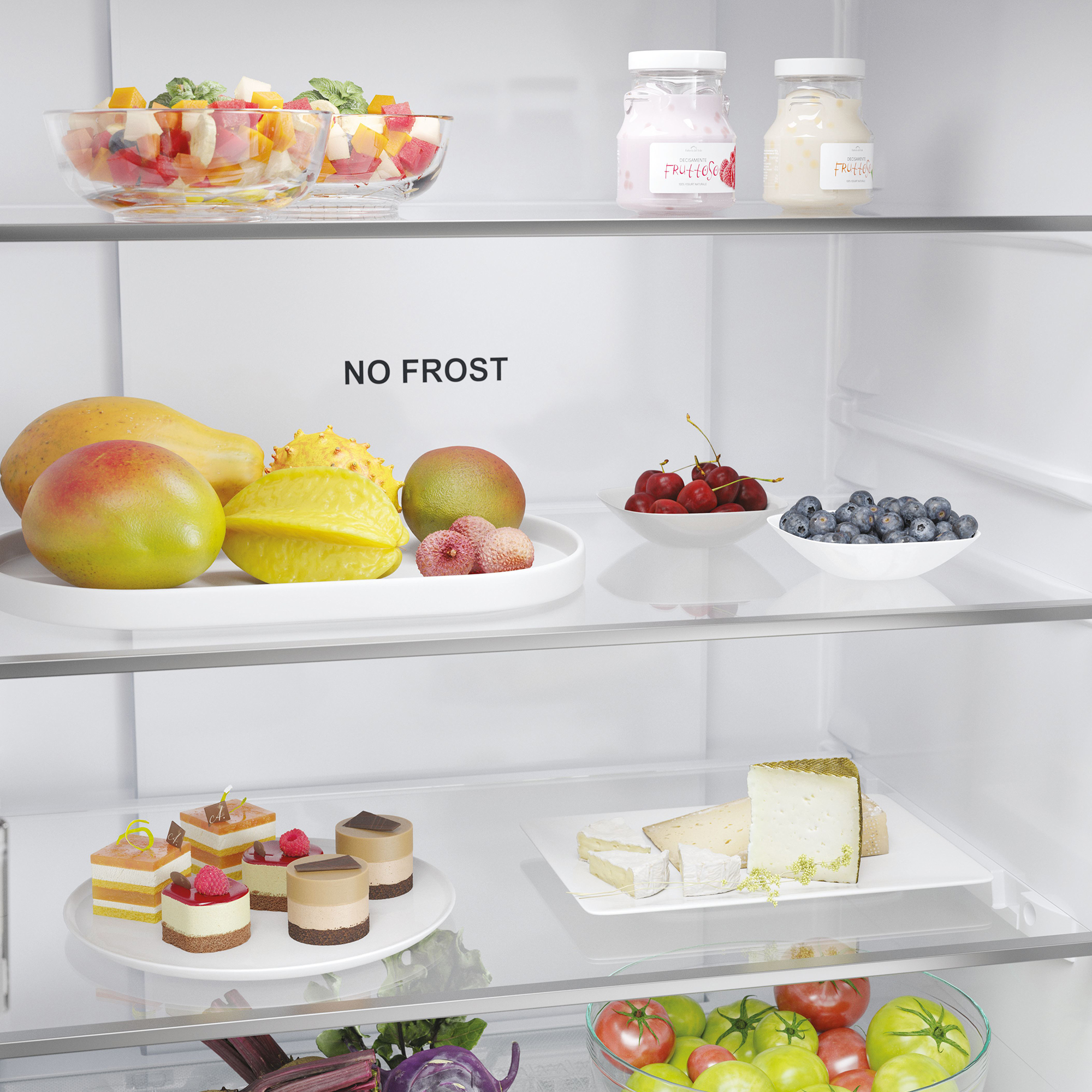 Ripiani del frigorifero con frutta, torte, formaggio e yogurt.