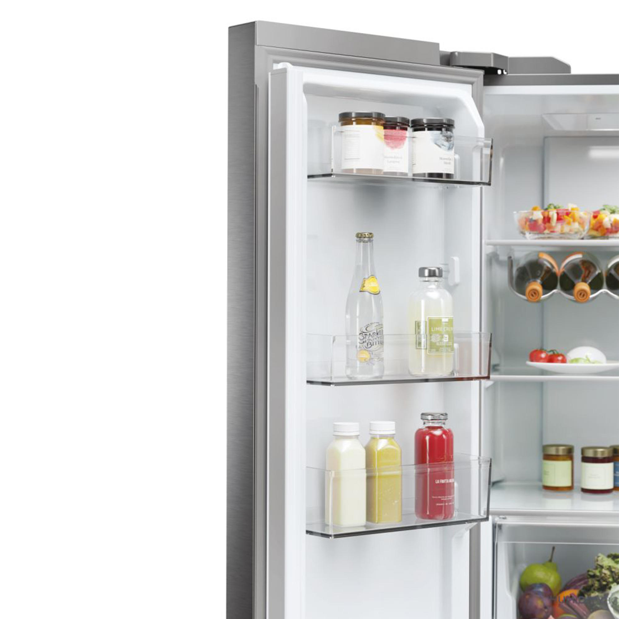 Un refrigerador abierto con frascos, botellas y frutas en los estantes.