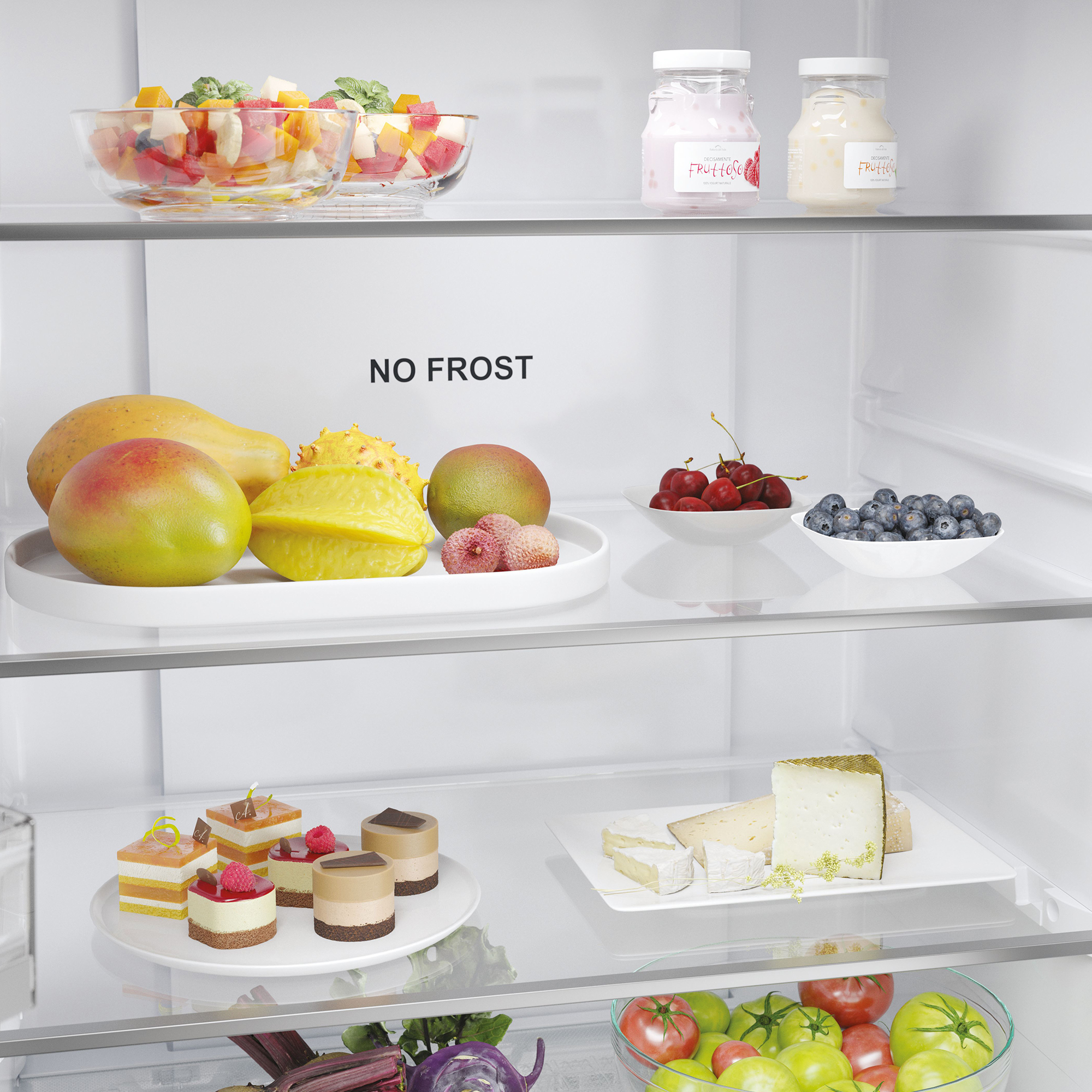Un refrigerador con frutas, pasteles y quesos.