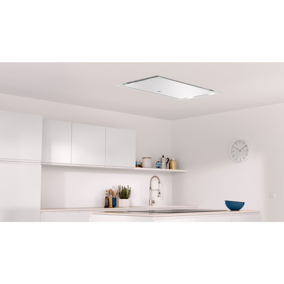 Una moderna cucina bianca con cappa a soffitto, lavello, piano cottura e orologio.