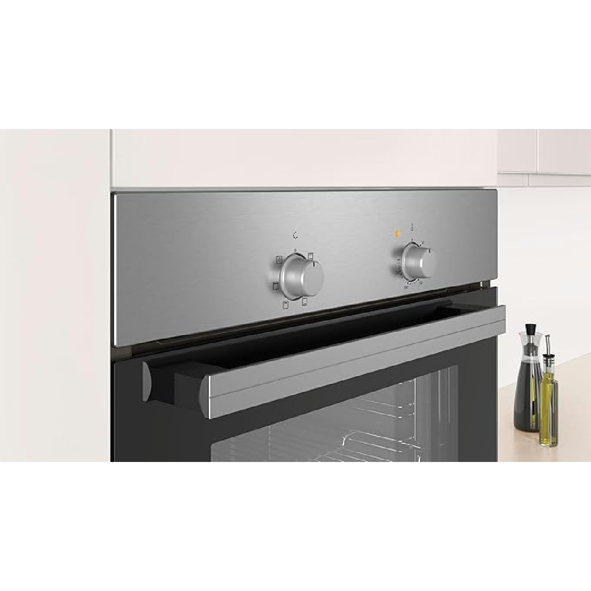 Roestvrijstalen oven met twee knoppen en glazen handvat, naast olieflessen.