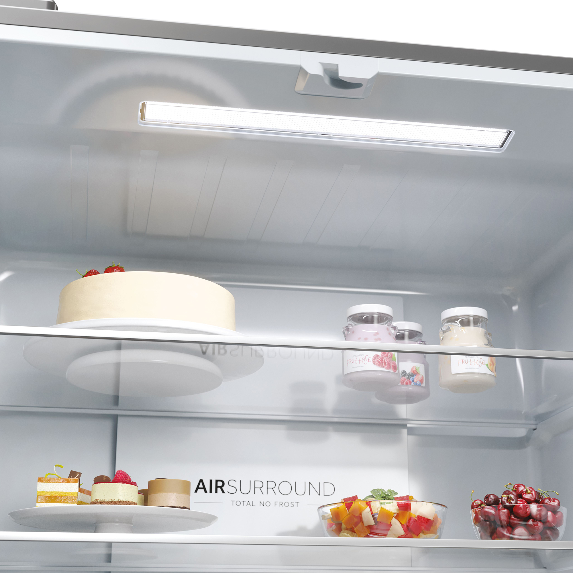Ein Kühlschrank mit Kuchen, Joghurt, Obstsalat und Kirschen.