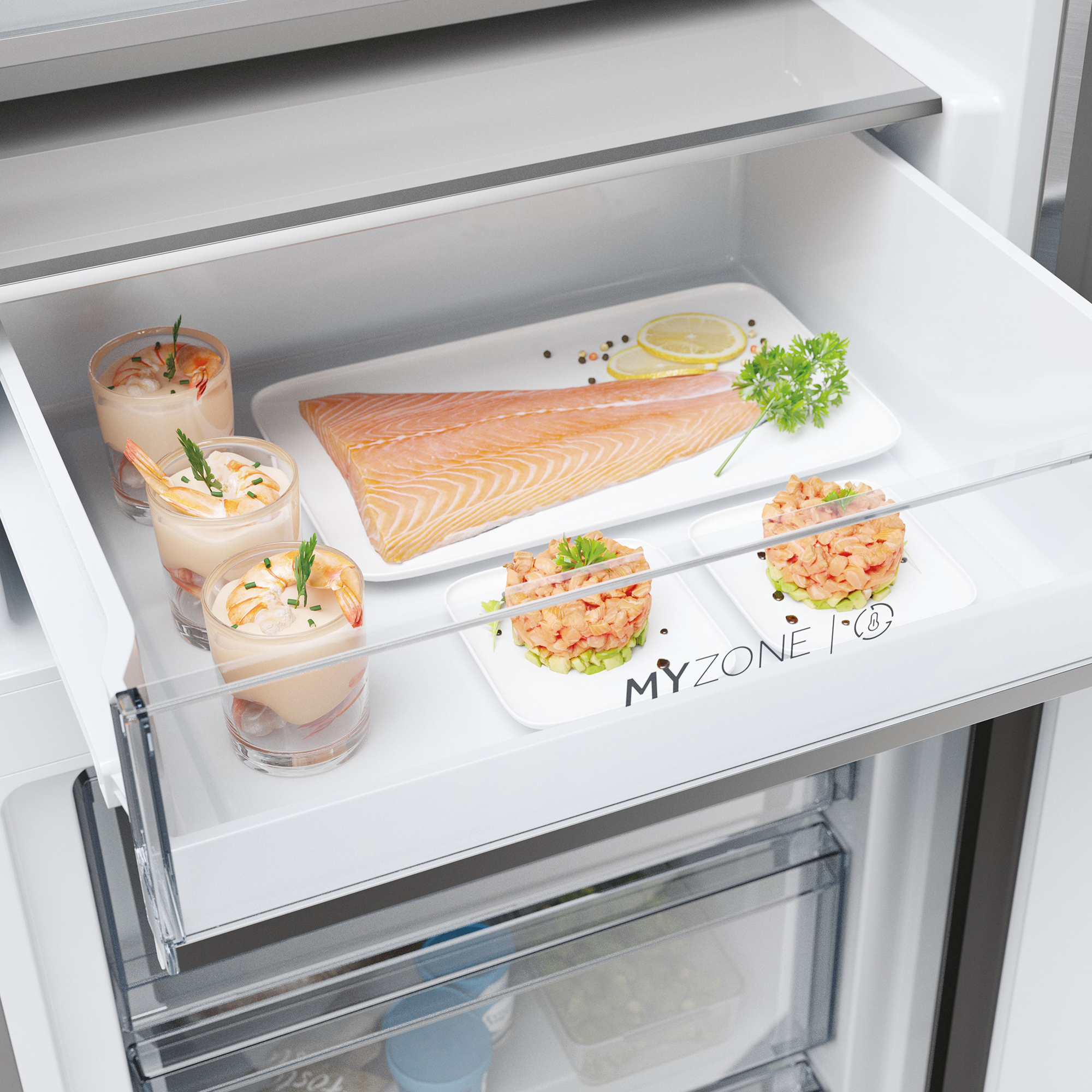 Un cajón de refrigerador con filete de salmón, cócteles de camarones y tártar de salmón.
