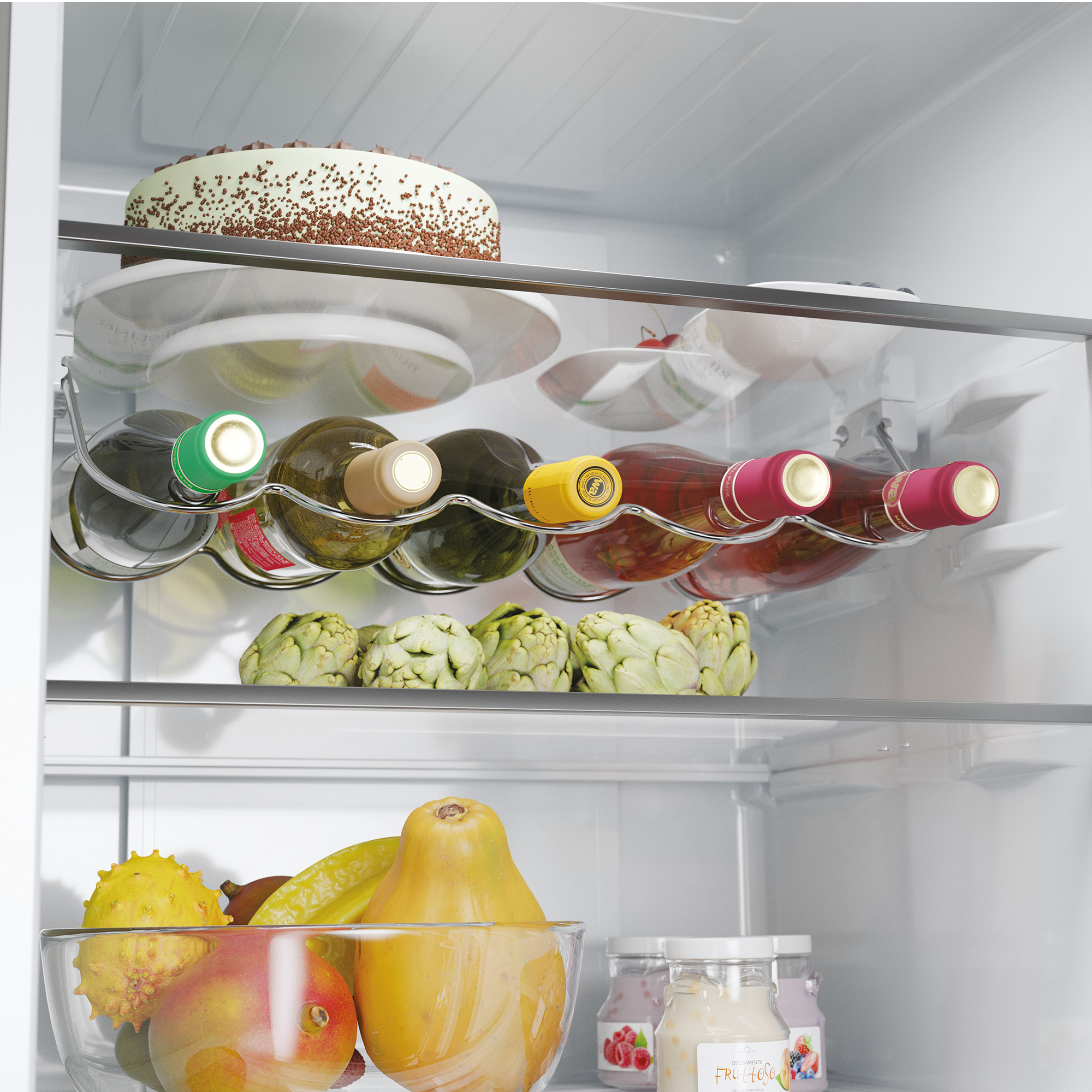 Interior de refrigerador con pastel, botellas de vino, alcachofas y frutero.