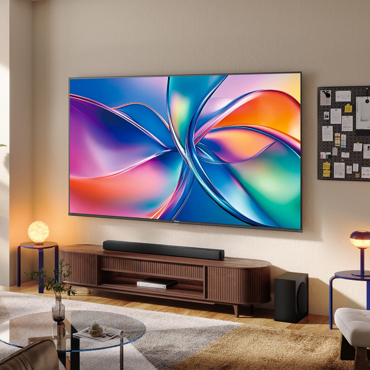 Sala de estar moderna con TV grande mostrando arte abstracto colorido, consola de medios de madera y mesa de centro de cristal.