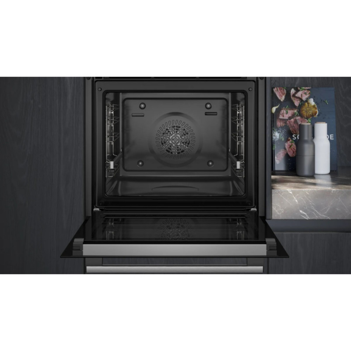 Un forno da incasso aperto con interno nero e ventola.