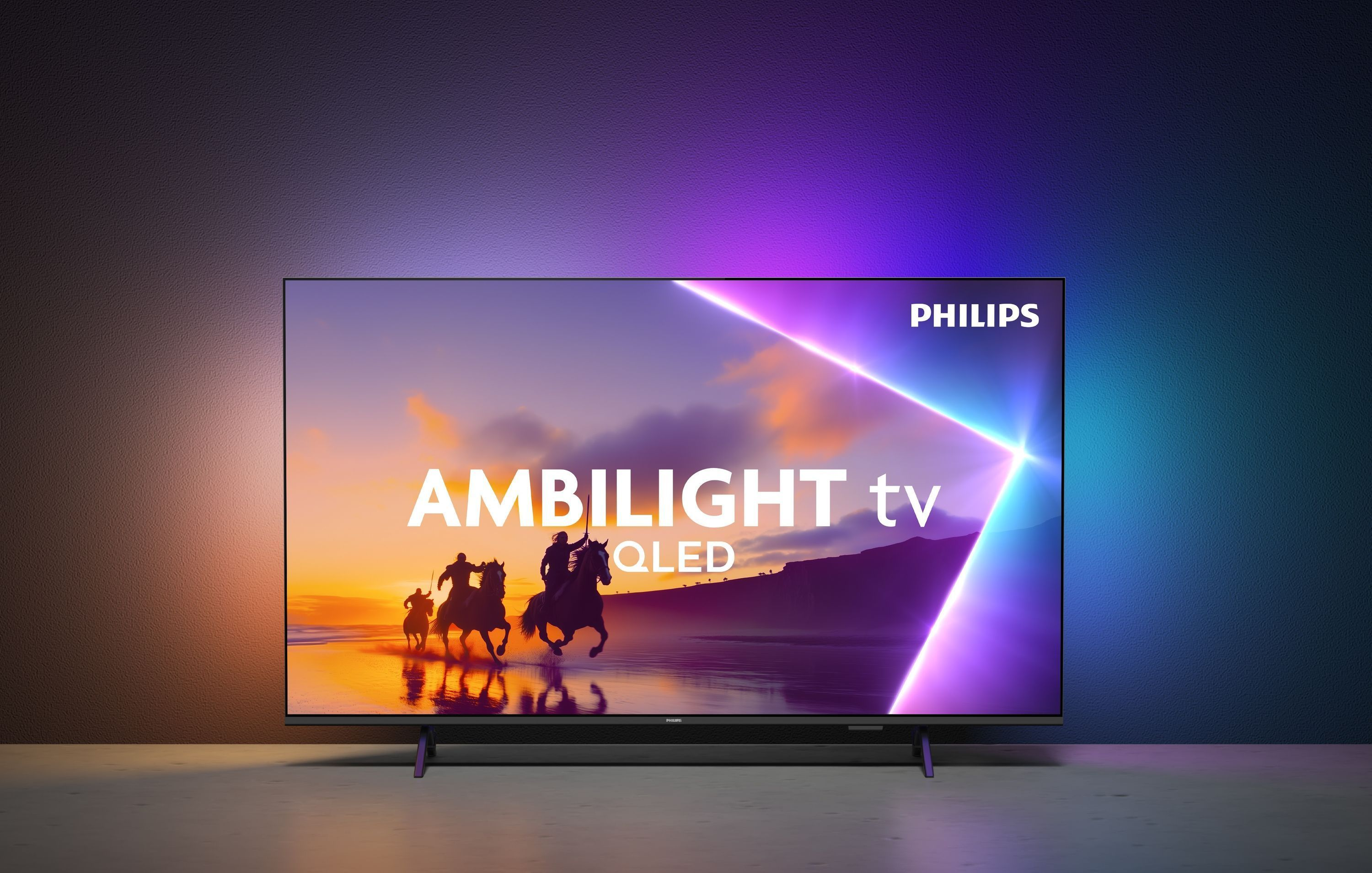 Una TV Philips Ambilight QLED mostra una scena di cavalieri su una spiaggia.