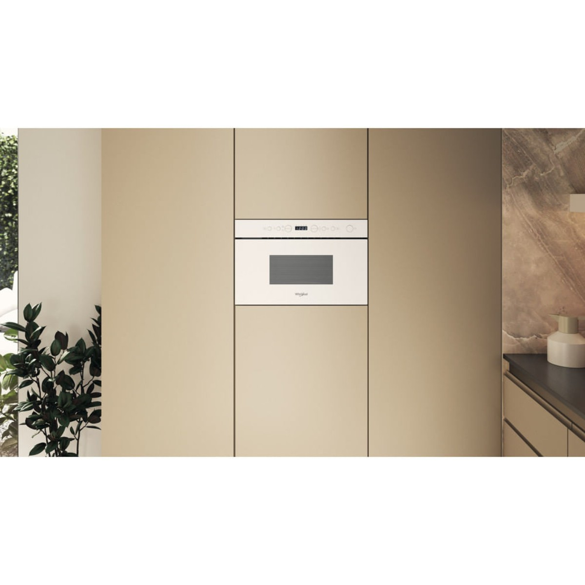 A white built-in microwave with a digital display in a beige kitchen unit.