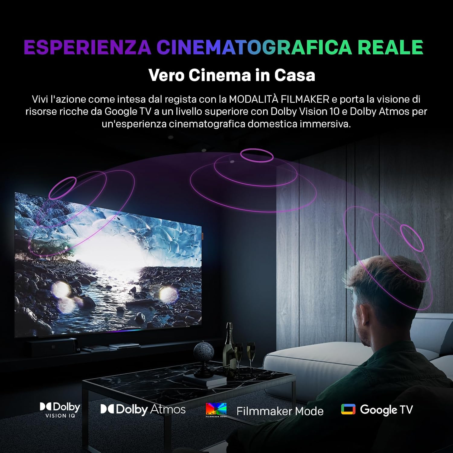 Un uomo seduto di fronte a un grande televisore che mostra un paesaggio ghiacciato.