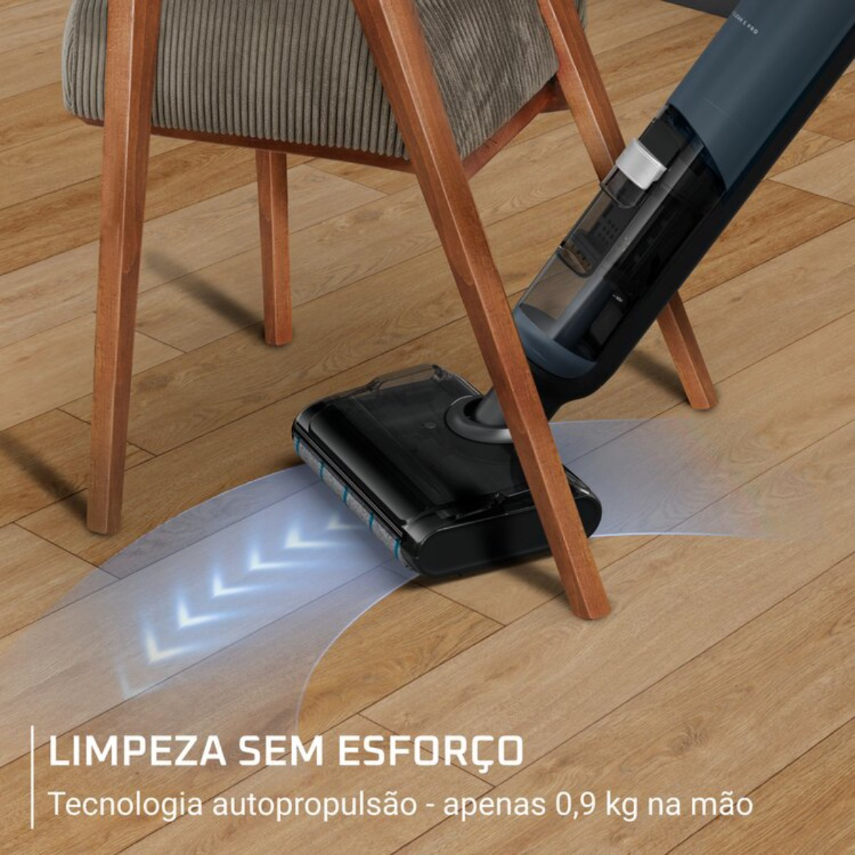 Una aspiradora inalámbrica azul limpia un suelo de madera junto a una silla.