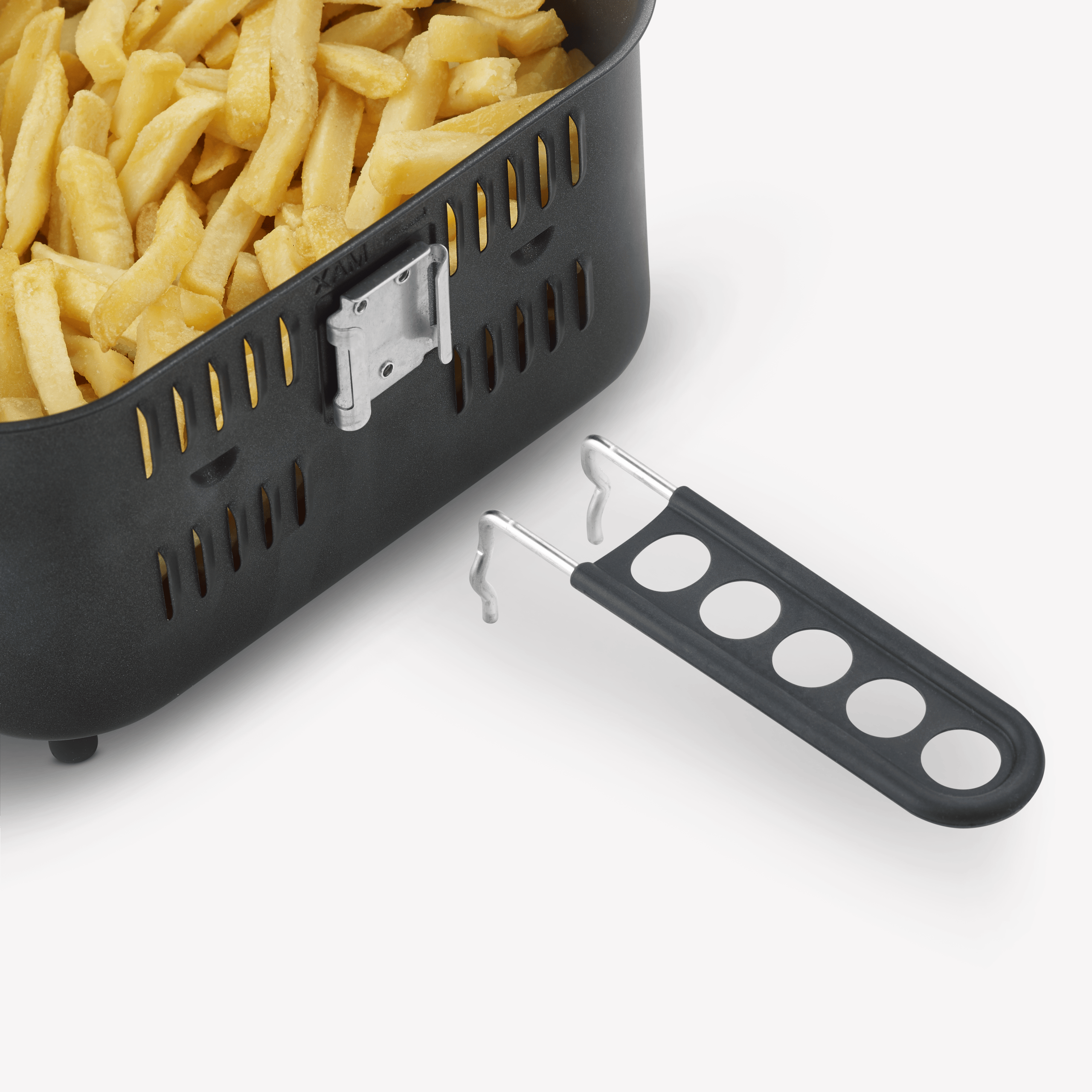 Un cestello nero per friggitrice ad aria pieno di patatine fritte dorate, con un manico staccabile accanto.