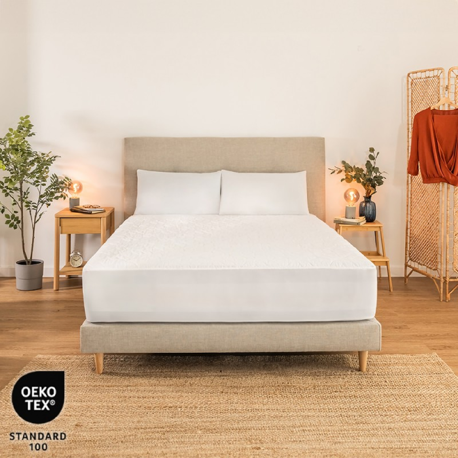 Un letto con lenzuola bianche, comodini con lampade e uno schermo in vimini con una camicia.