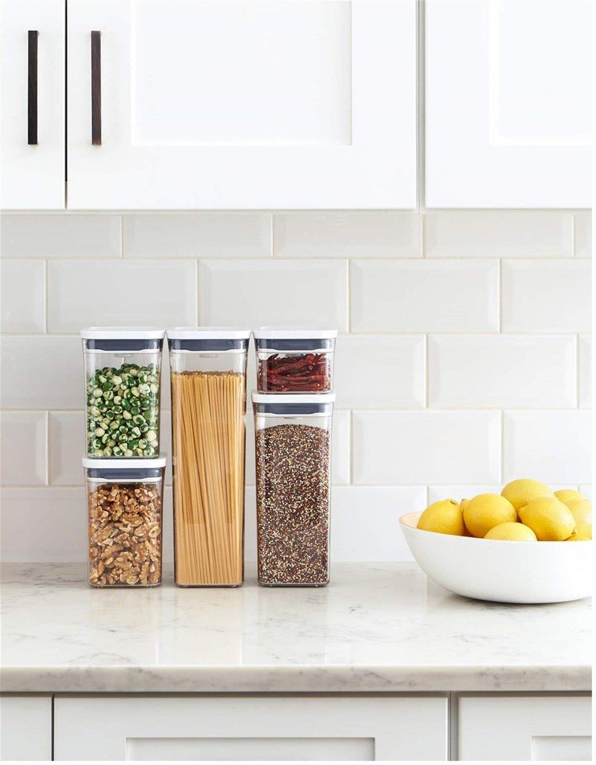 Cucina: Dispensa con barattoli di noci, pasta, piselli, grani e peperoncini secchi.