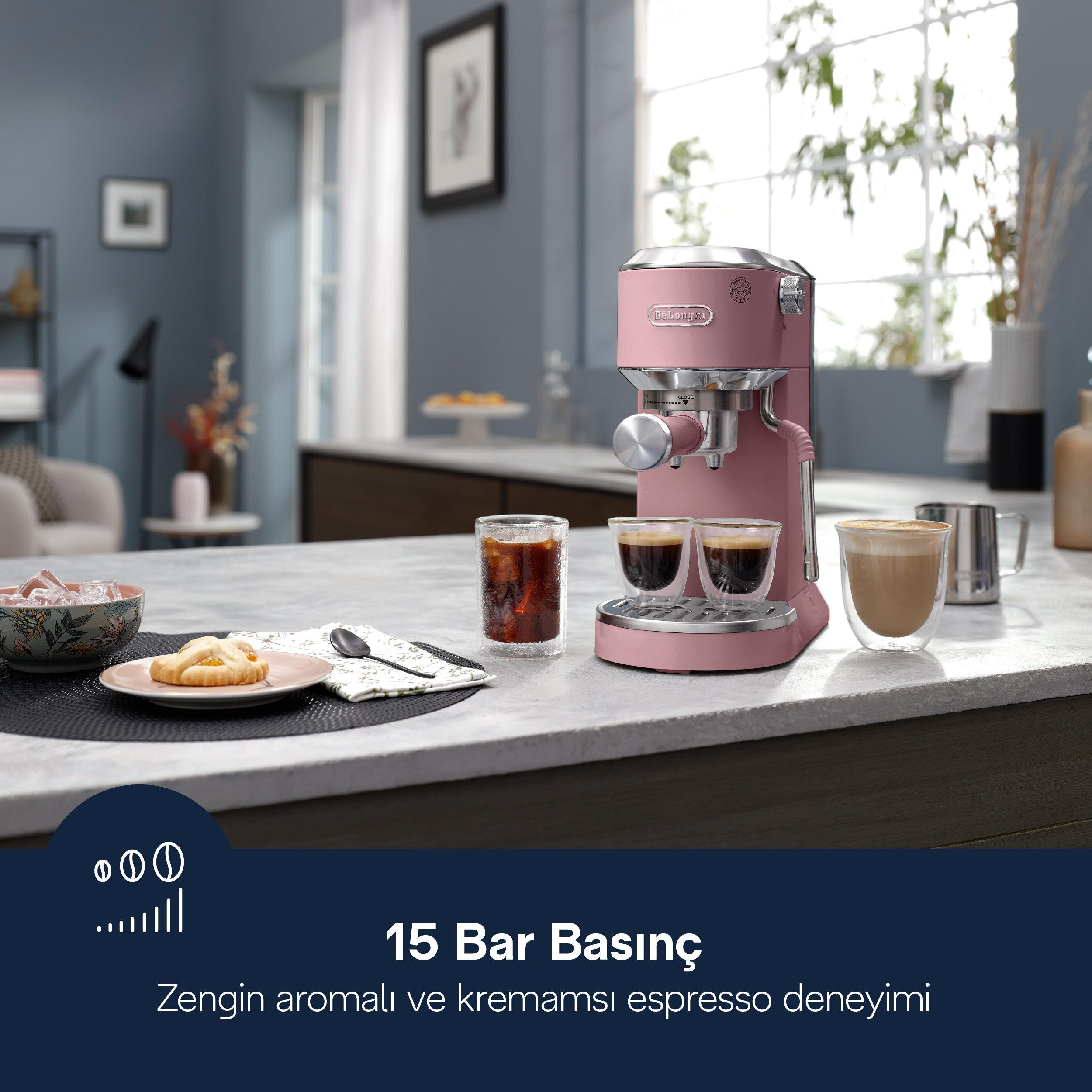 İki fincan kahve, kruvasan ve buz küpleri olan pembe espresso makinesi.