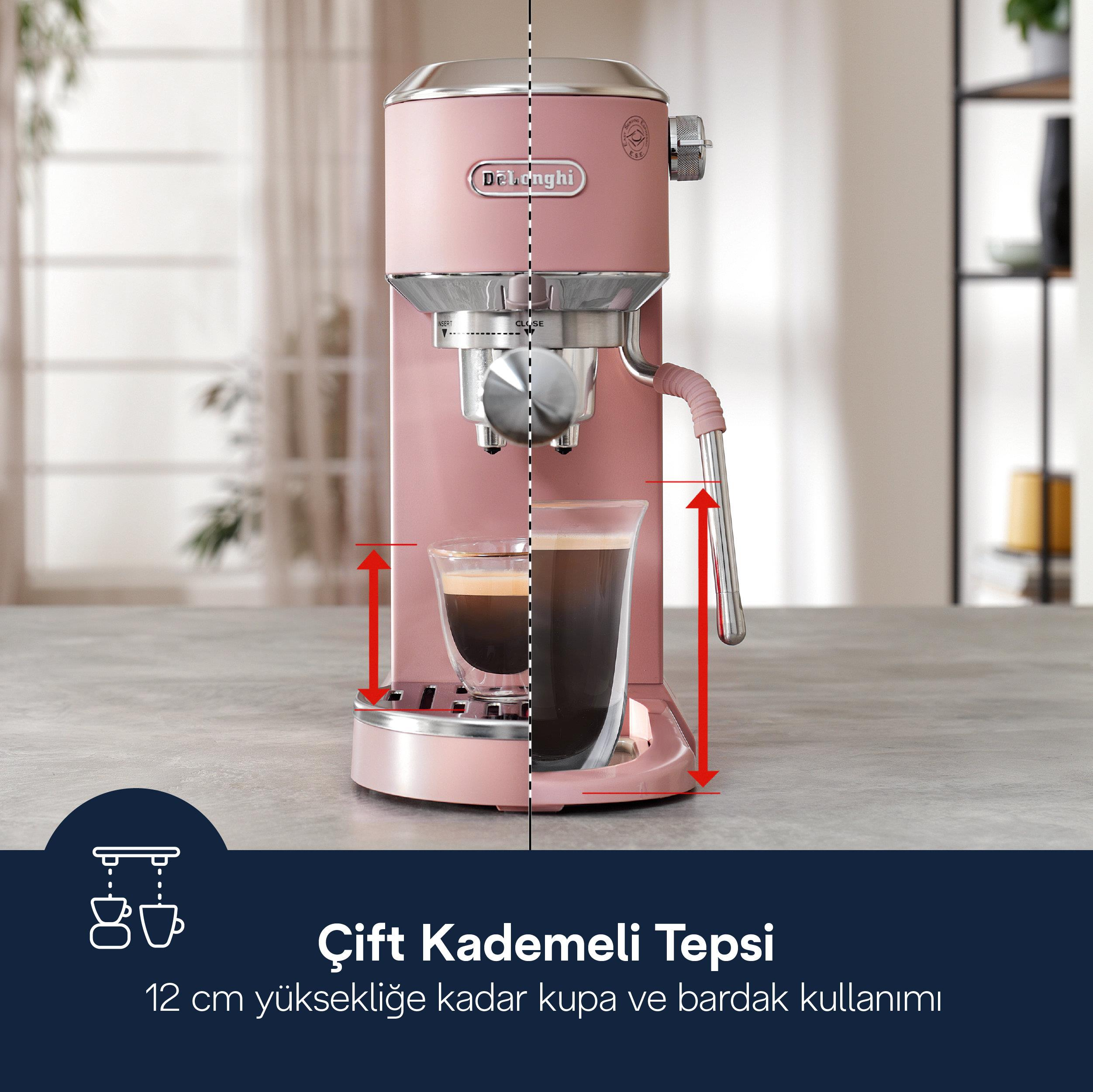 Pembe bir espresso makinesi masadaki bardağa kahve yapıyor.