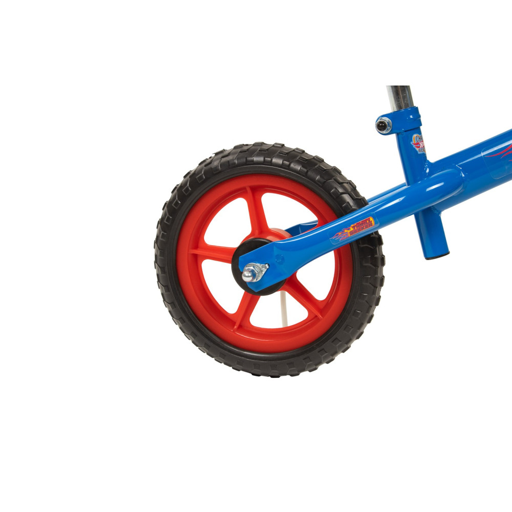 Niebieski rower ma czerwone koło z czarną oponą i naklejką Hot Wheels.