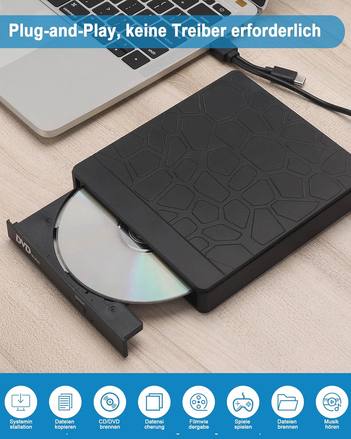Schwarzer externer DVD-Brenner mit eingelegter DVD neben einem Laptop.