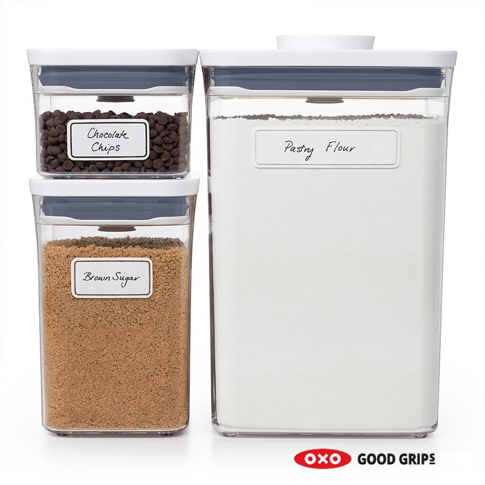 Tre contenitori trasparenti OXO Good Grips: farina, zucchero di canna e gocce di cioccolato.