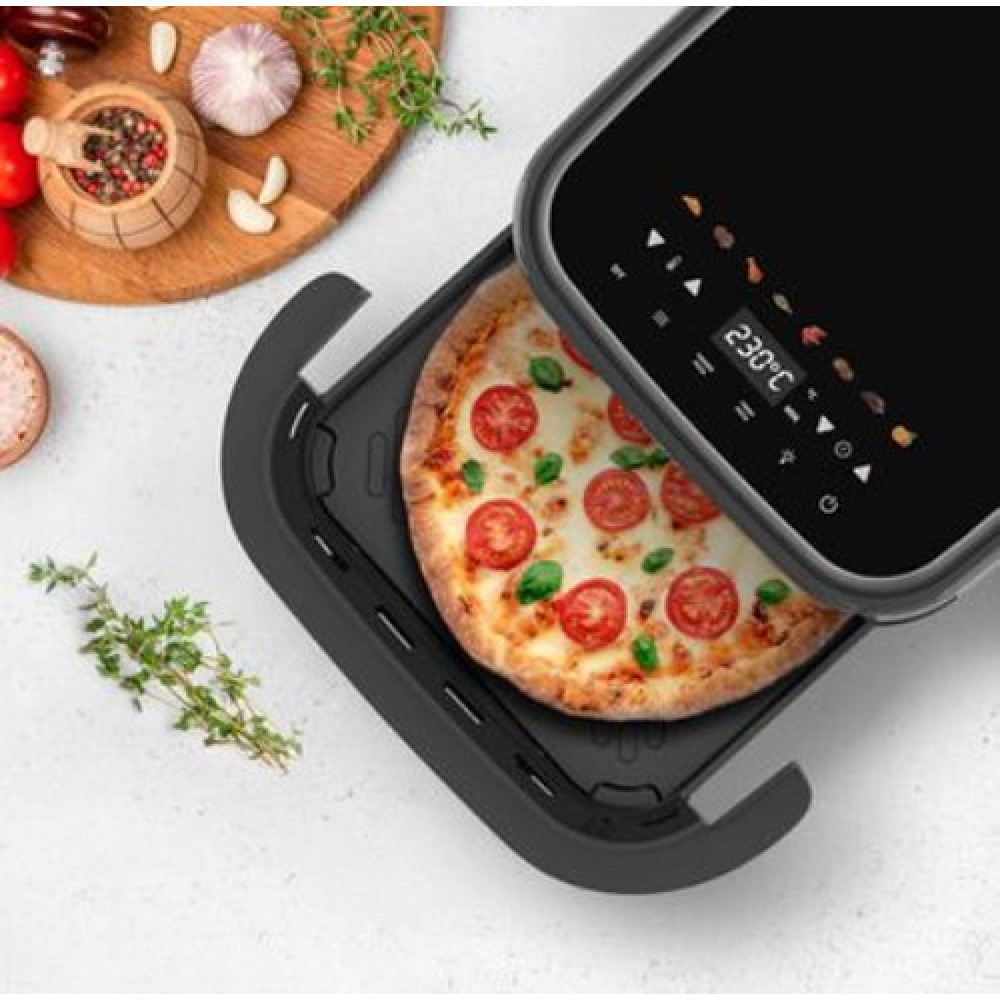 Una pizza con pomodoro e basilico in friggitrice ad aria nera con display digitale.
