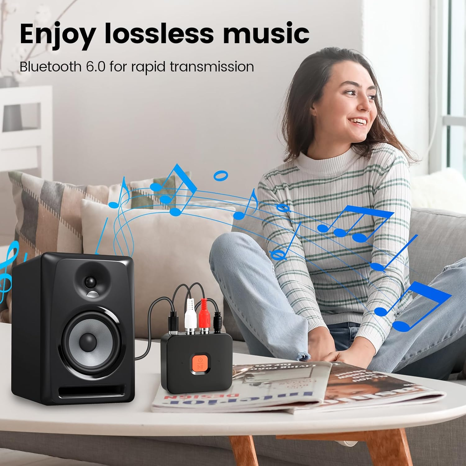 Ein schwarzer Lautsprecher und ein schwarzer Bluetooth-Empfänger auf einem Tisch mit Musiknoten.