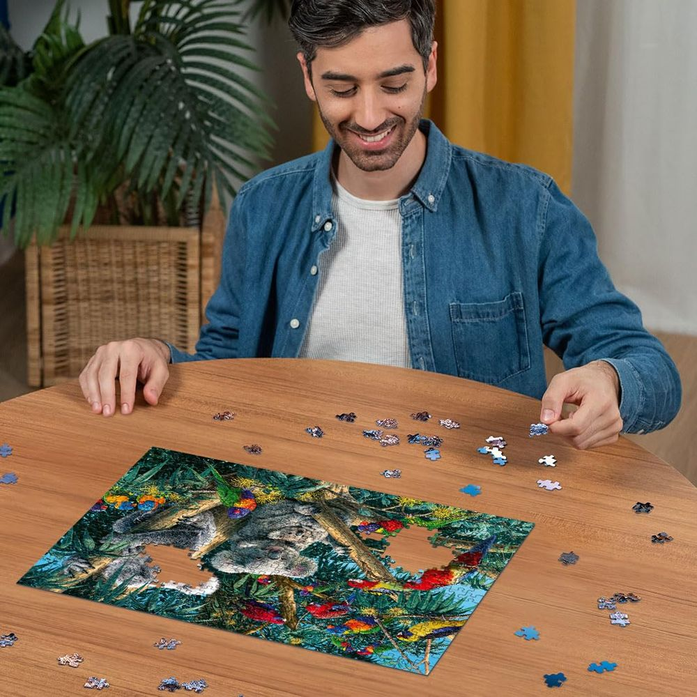 Man zit aan een houten tafel, een puzzel van koala's en kleurrijke vogels leggend.