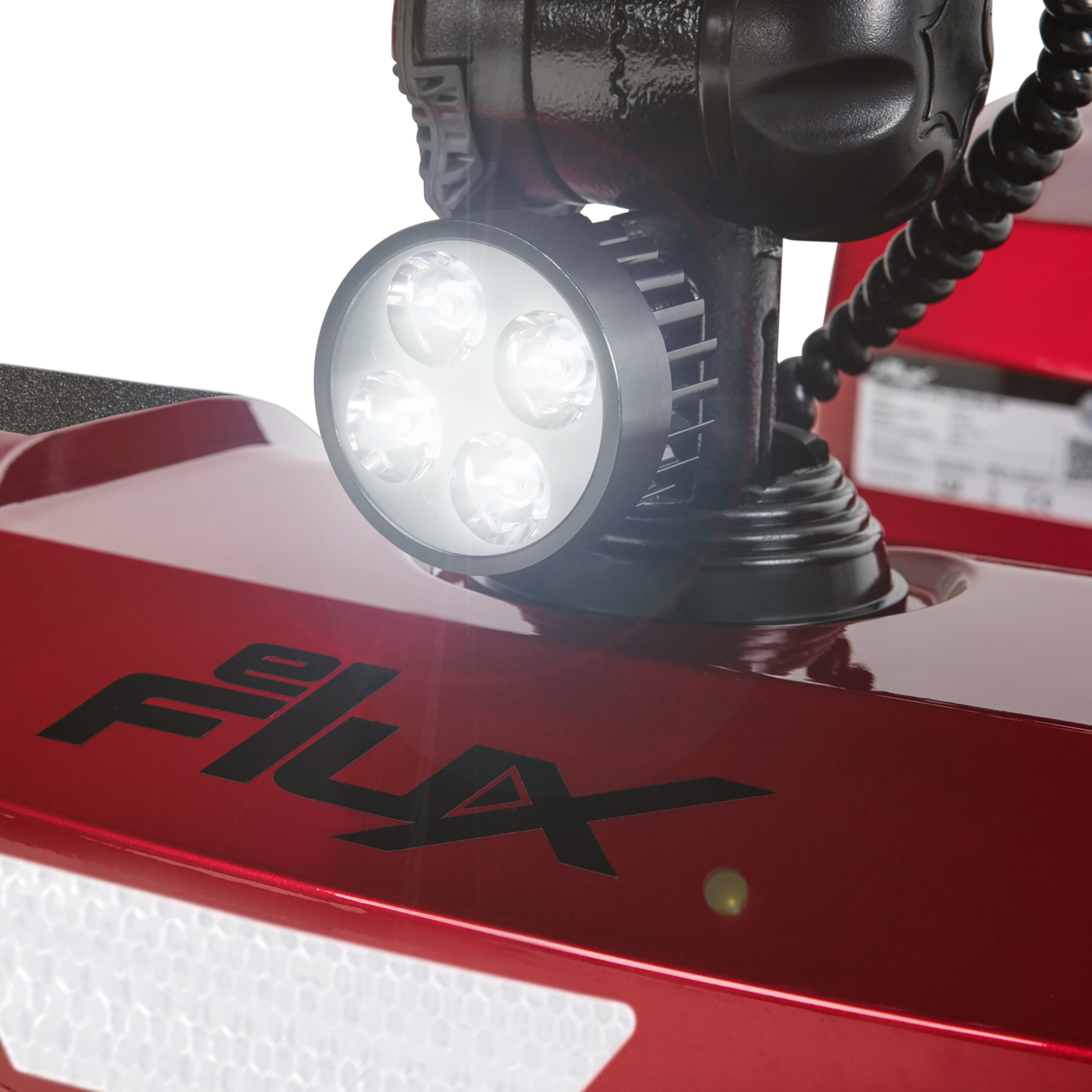 Ein roter Roller mit einem hellen LED-Scheinwerfer und dem Logo "FLUX".