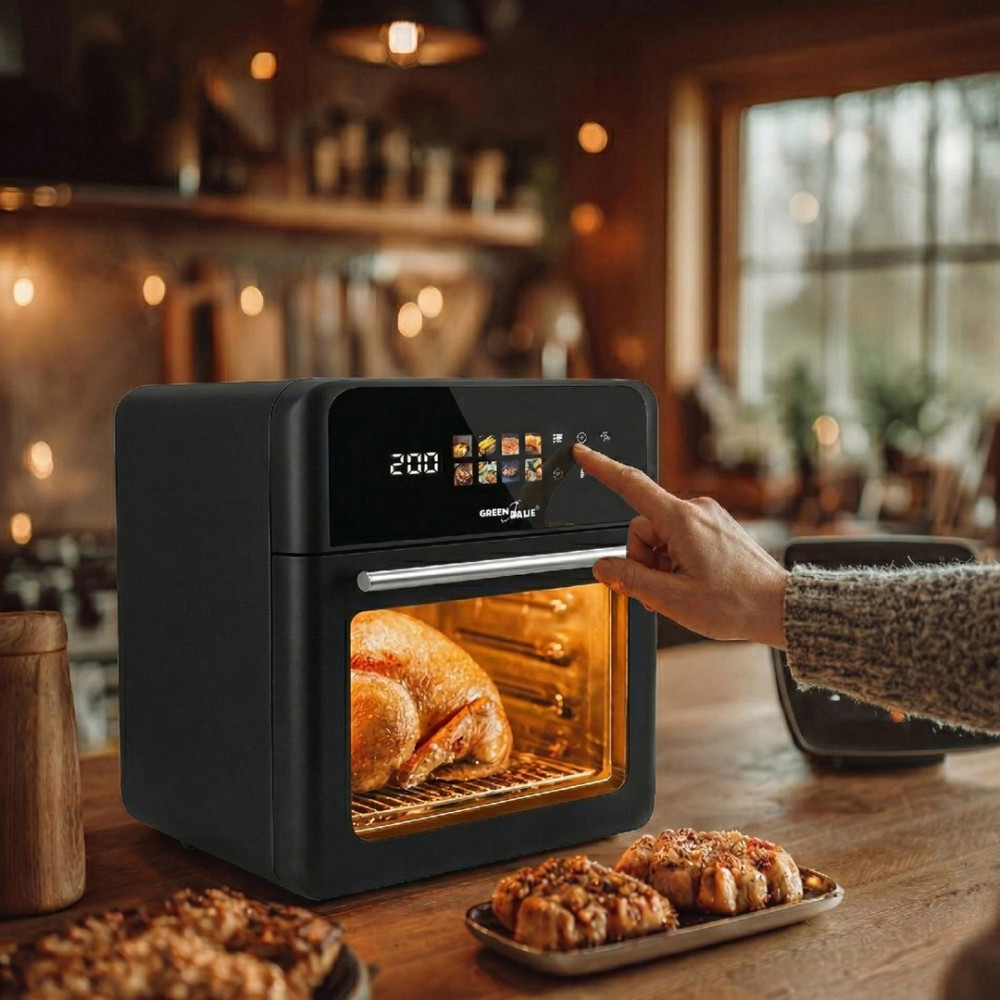 Forno friggitrice ad aria nero con pollo arrosto e pasticcini su tavolo legno.