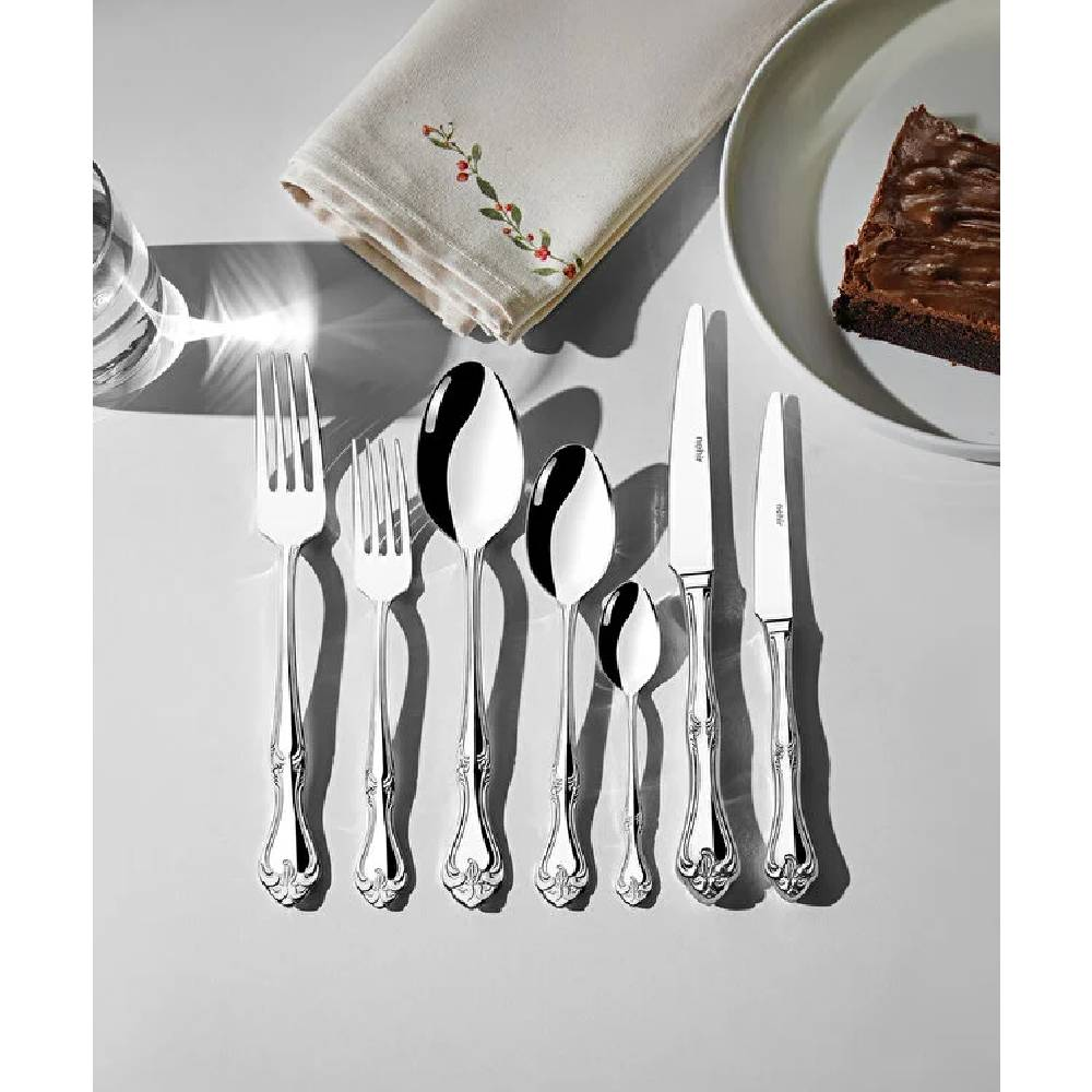 Süslü saplı parlak çatal bıçak takımı, tabaktaki brownie'nin yanında.