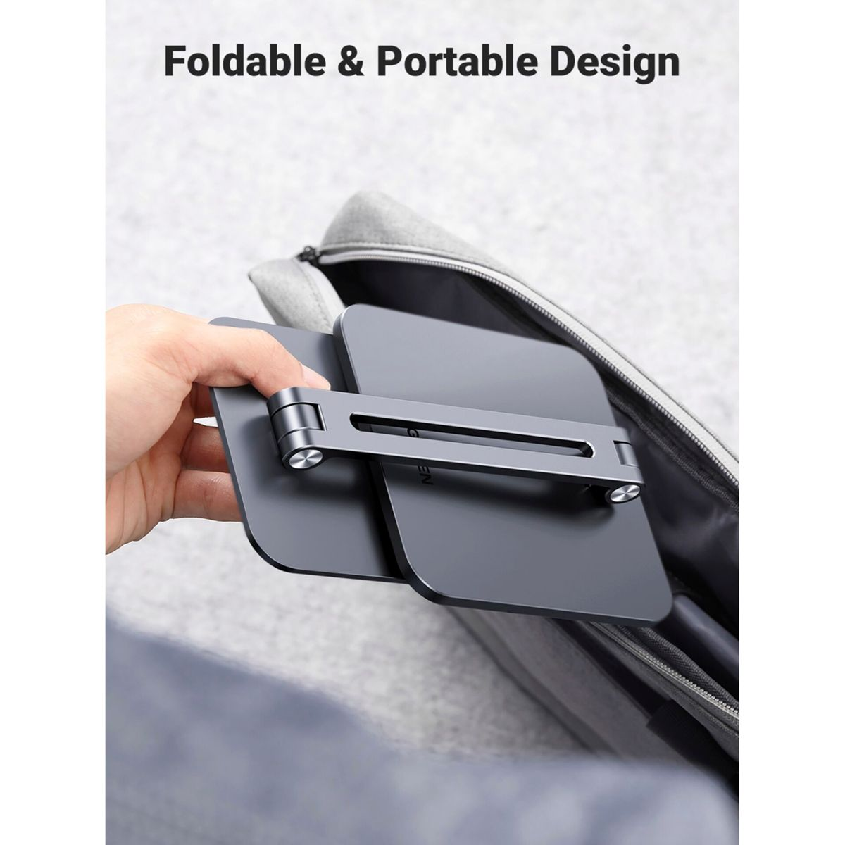 Un supporto pieghevole grigio per laptop viene riposto in una borsa.