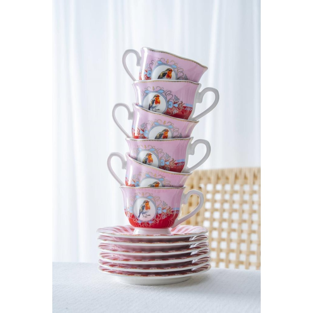 Kuş desenli pembe çay fincanları ve uyumlu tabak yığını.