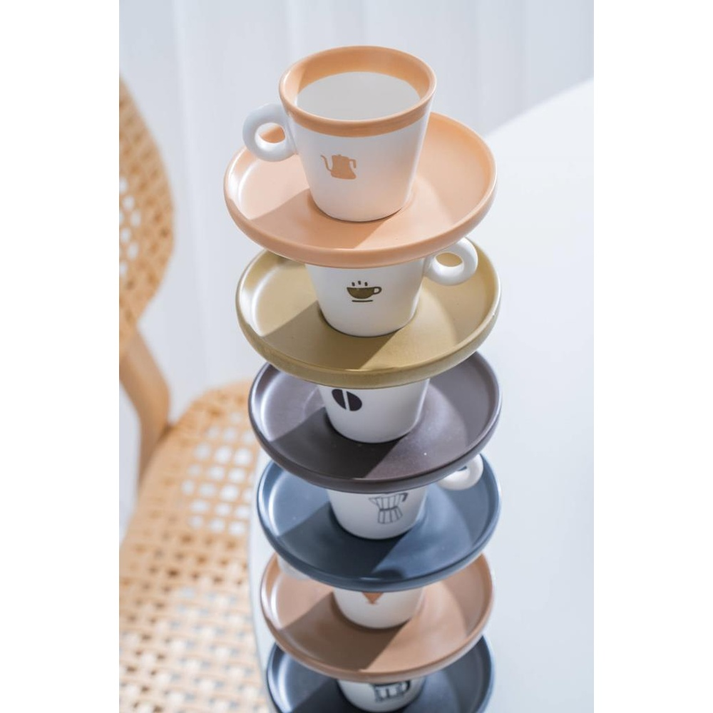Çeşitli pastel renkli kahve fincanları ve tabaklarının üst üste dizilmiş hali.