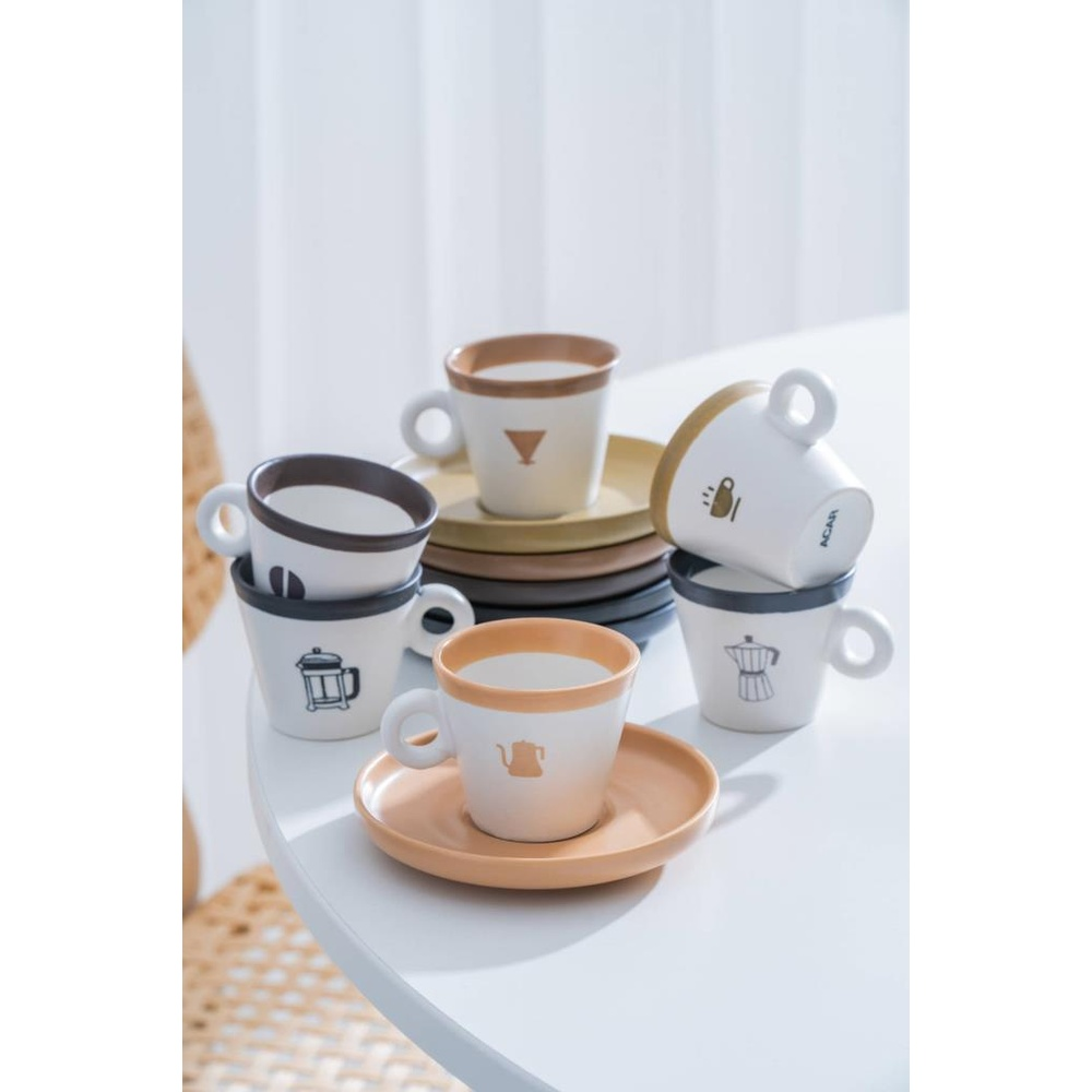 Beyaz bir masada kahve motifli birkaç espresso fincanı ve tabağı.