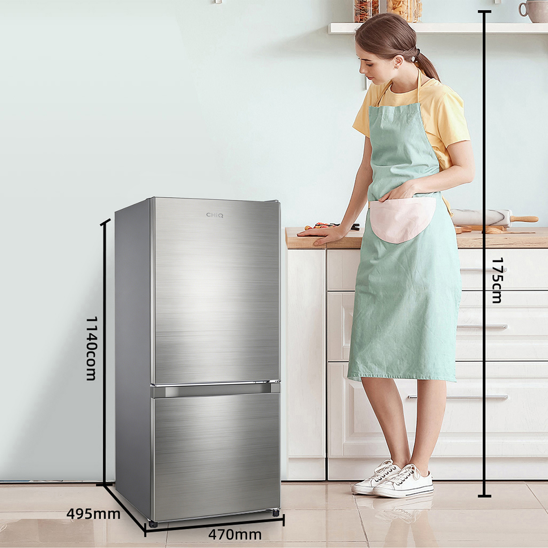 Eine Frau steht neben einem silbernen Kühlschrank in einer Küche. Maße sind angegeben.