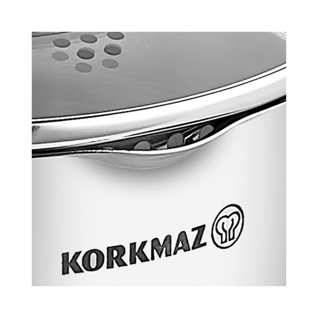 Korkmaz logosunun beyaz zeminde yakın çekimi. Delikli metal yüzey.
