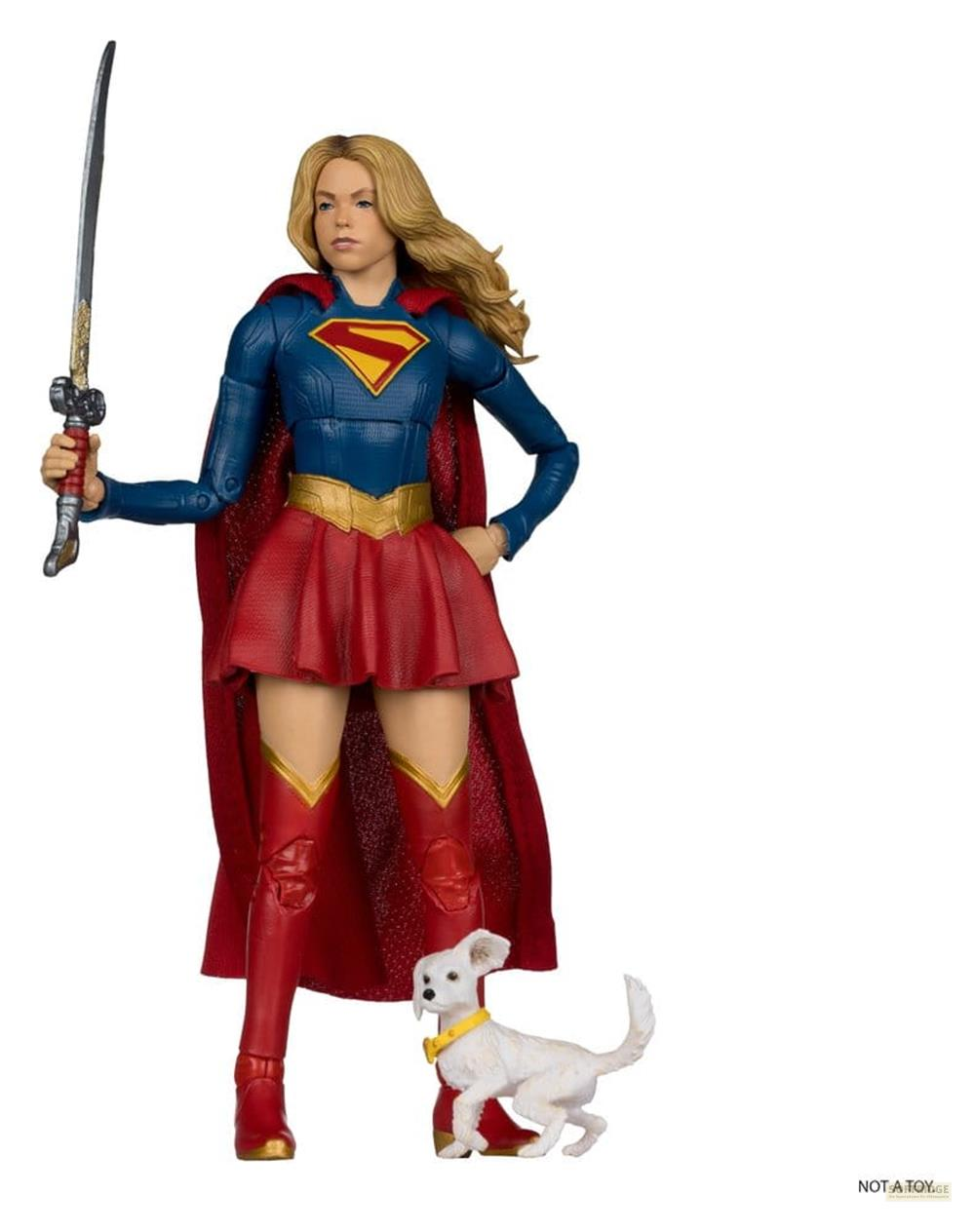 Supergirl-Figur in blau/rotem Anzug mit Schwert und ein weißer Hund mit gelbem Halsband.