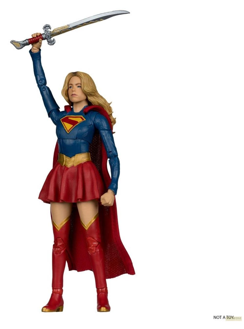 Supergirl-Figur mit Schwert hält sie erhoben. Sie trägt blaues Oberteil, roten Rock und Stiefel.