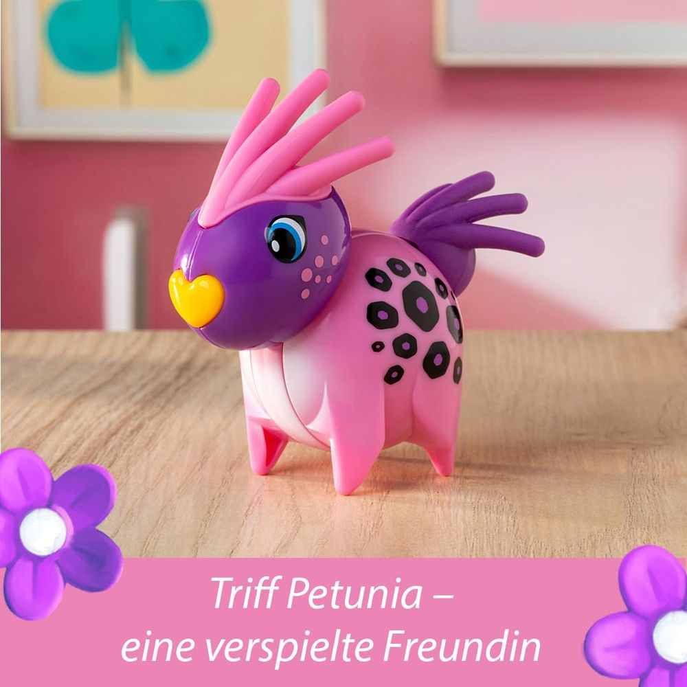 Ein pink-lilanes Spielzeugtier mit gelber Nase und blauen Augen steht auf einem Holztisch.