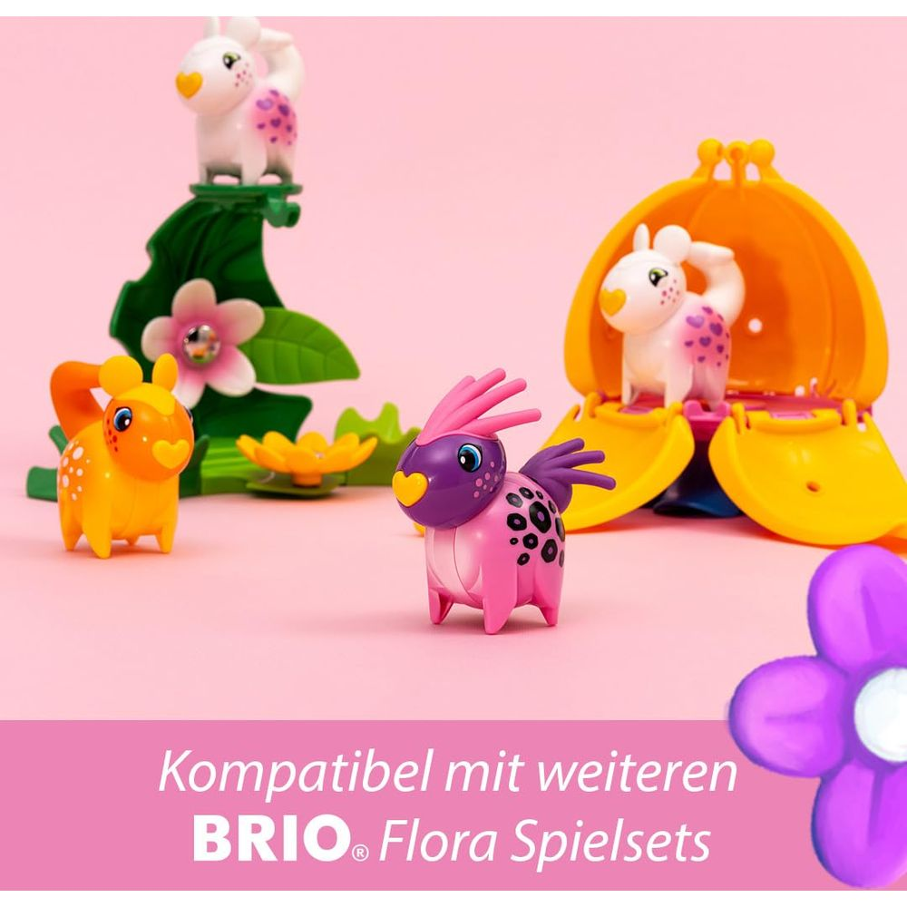 Bunte Spielzeugtiere und eine orangefarbene Muschel auf rosa Hintergrund.