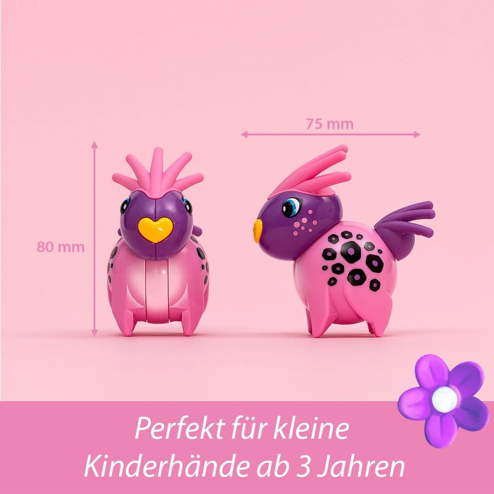 Zwei pinke Spielzeugvögel mit lila Köpfen stehen nebeneinander auf rosa Hintergrund.