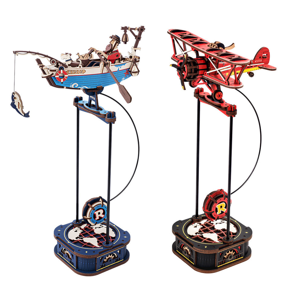 Maquettes en bois d'un bateau de pêche et d'un biplan sur des supports.